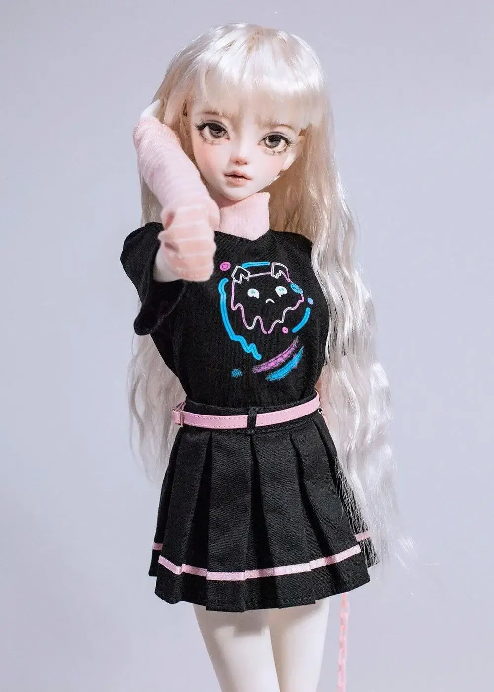 1/4 scale BJD outfit featuring a black t-shirt with graphic, pleated skirt, and long blonde hair, modeled by a girl doll.