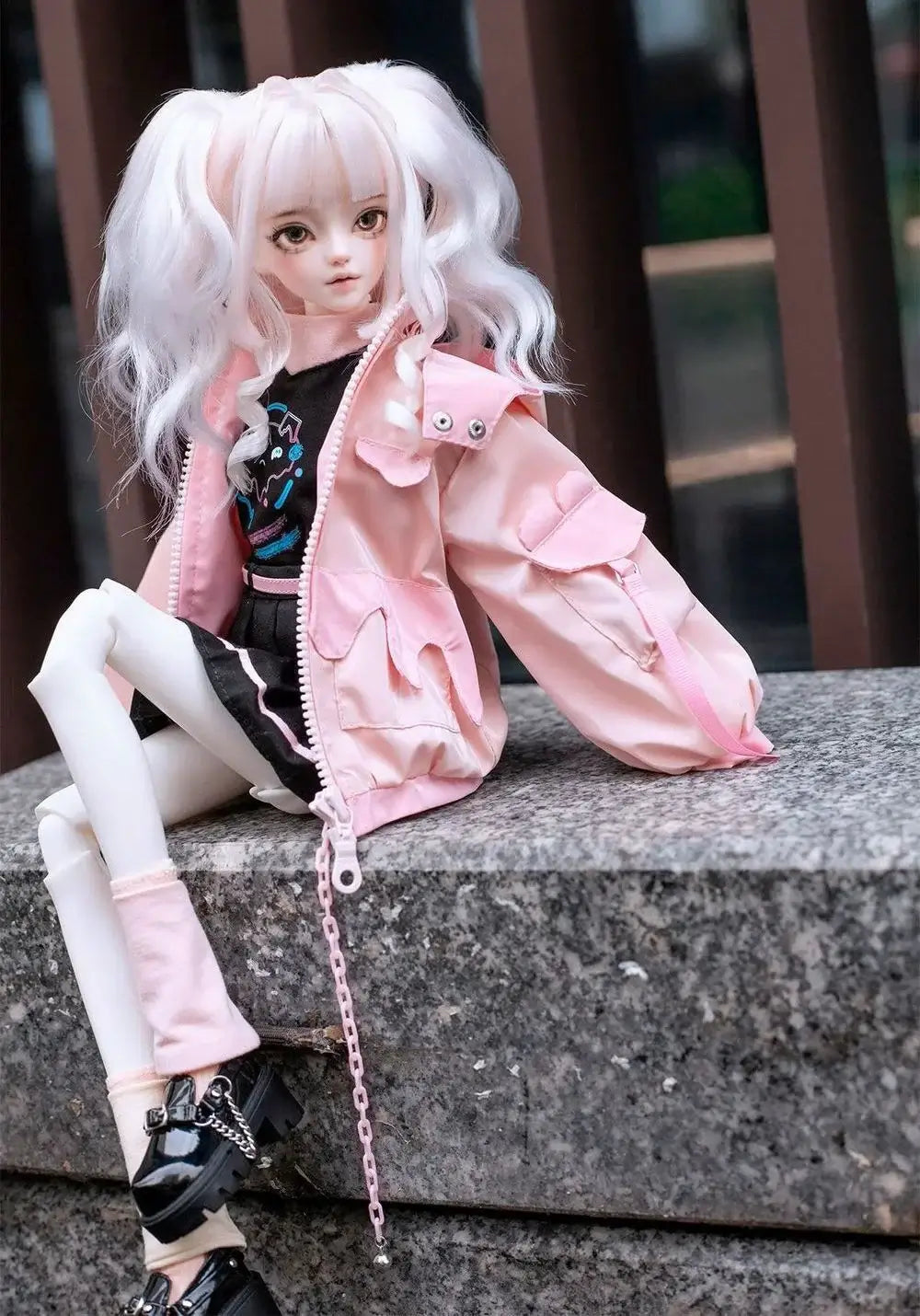 BJD doll wearing a pink jacket and stylish outfit, sitting on a stone surface, showcasing trendy fashion for 1/4 size dolls.